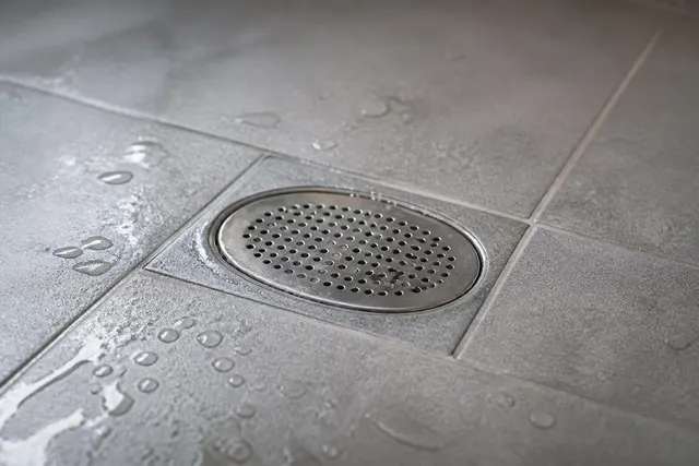 Ovales Haarsieb im Ablauf einer Dusche
