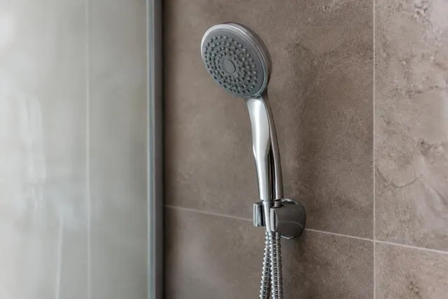 Handbrause mit Strahlscheibe und Schlauch in einer Dusche