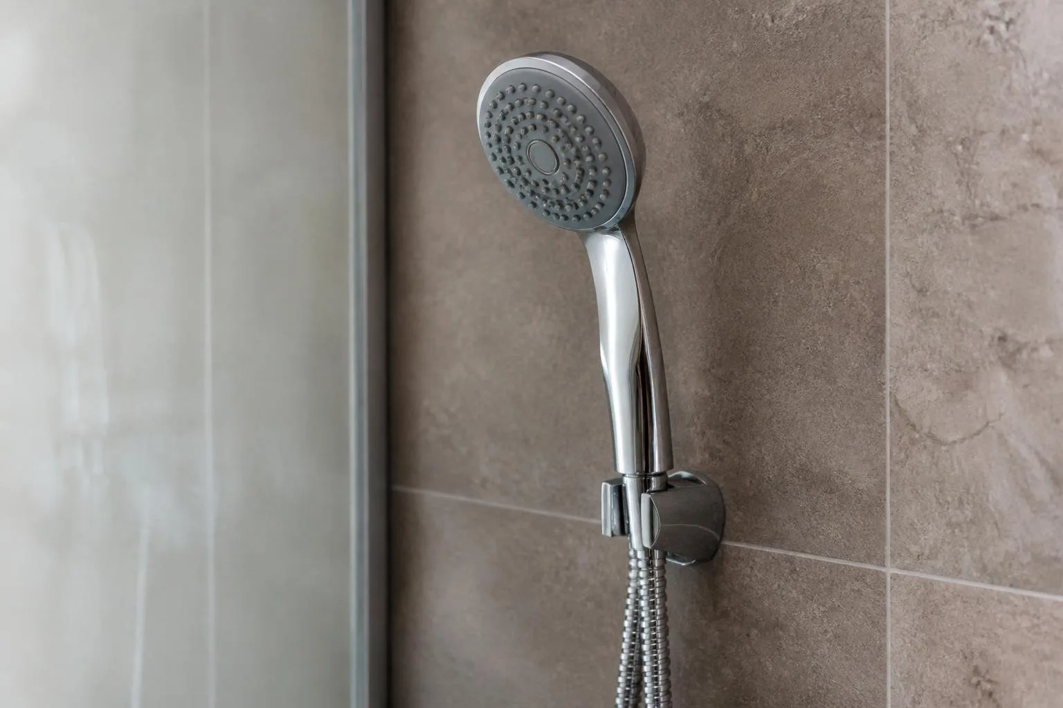Handbrause mit Strahlscheibe und Schlauch in einer Dusche