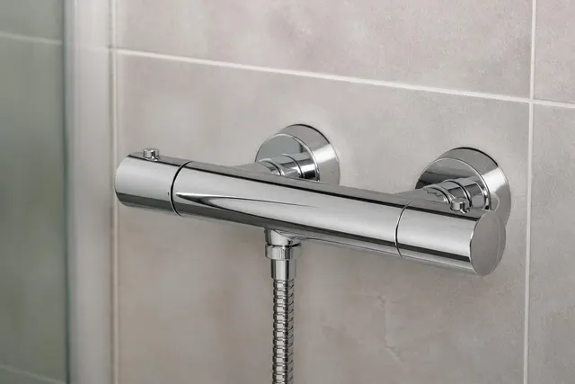 Thermostat-Brausearmatur an einer gefliesten Duschwand