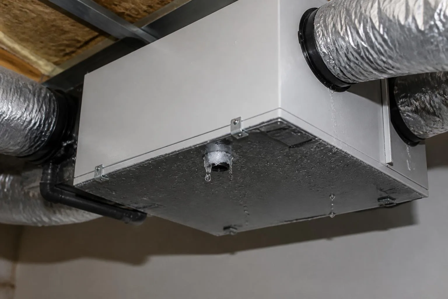 Lüftungsgerät mit sichtbaren Wassertropfen und einer kleinen Eisbildung am Kondensatbereich